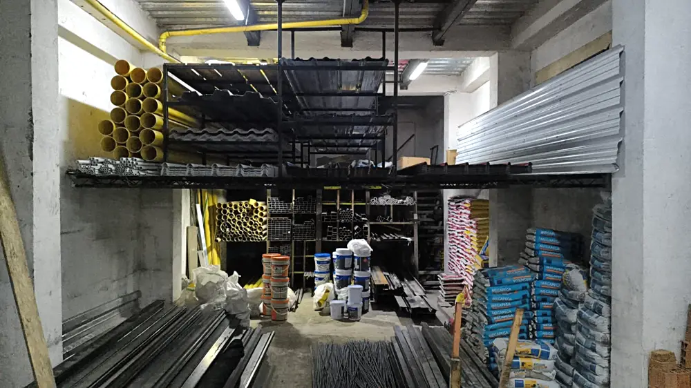Bodega de FerreAceros en Pereira: teja galvanizada, metaldeck, tuberia, perfileria, varilla y cemento en estanteria.